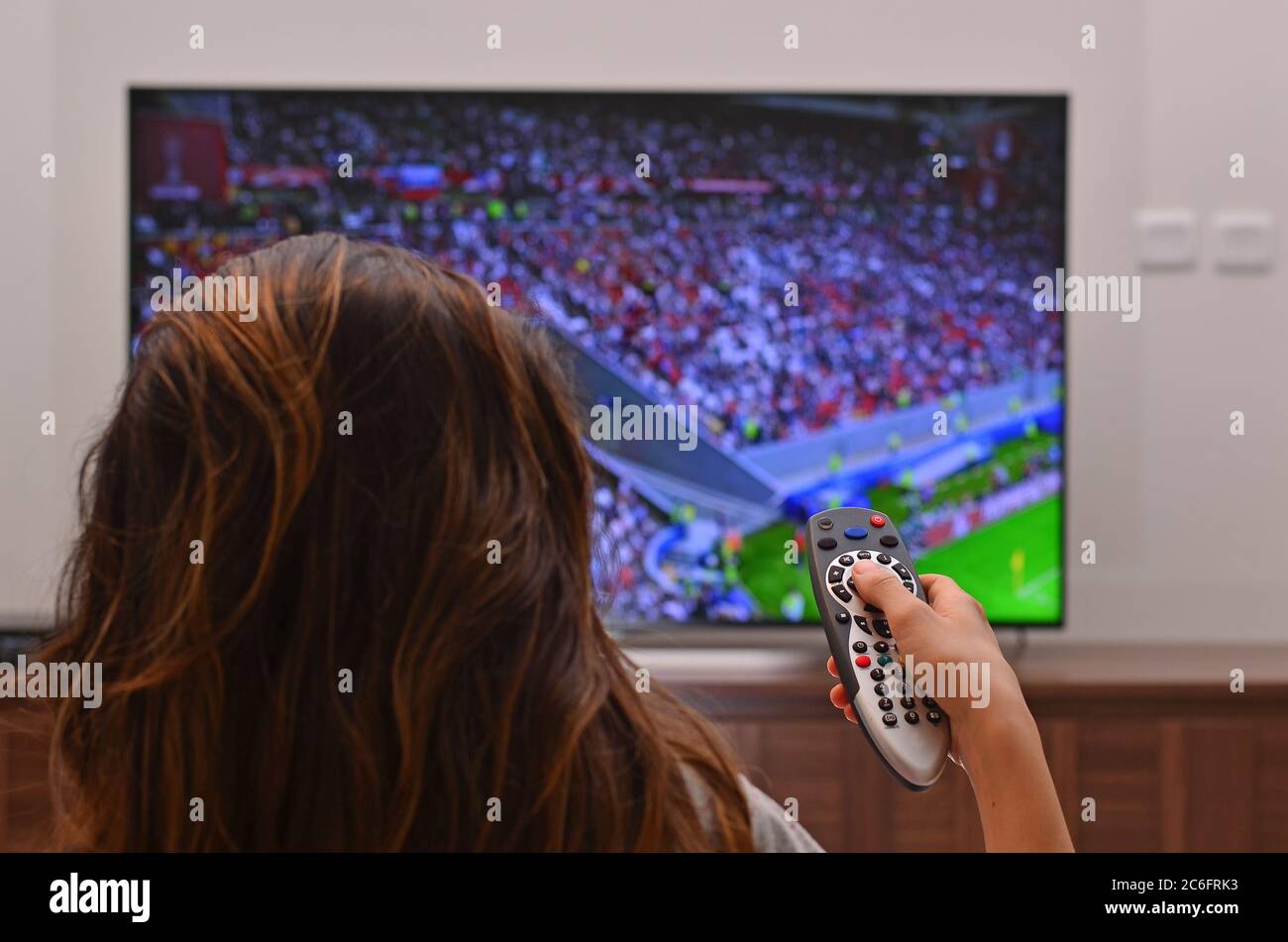 Les femmes regardent un match de football à la télévision et utilisent la télécommande Banque D'Images
