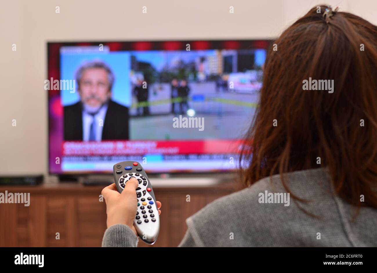 Les femmes regardent les actualités télévisées et utilisent la télécommande Banque D'Images