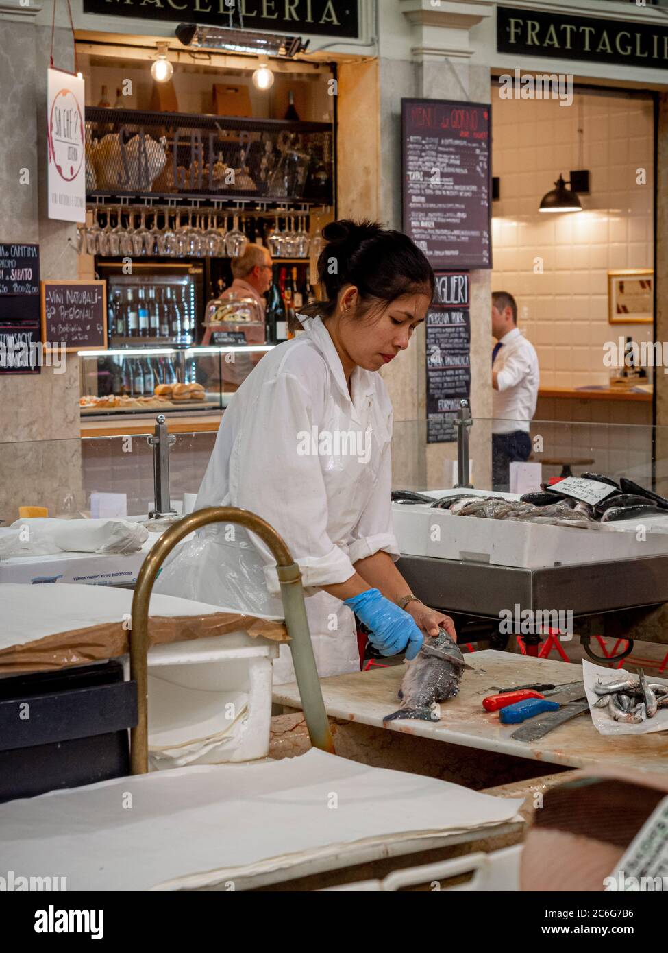 Femelle éviscérant un poisson à Mercato Albinelli, Modène, Italie. Banque D'Images