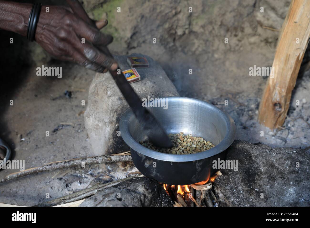 Femme préparant du café au feu, torréfaction de grains de café, Ouganda Banque D'Images