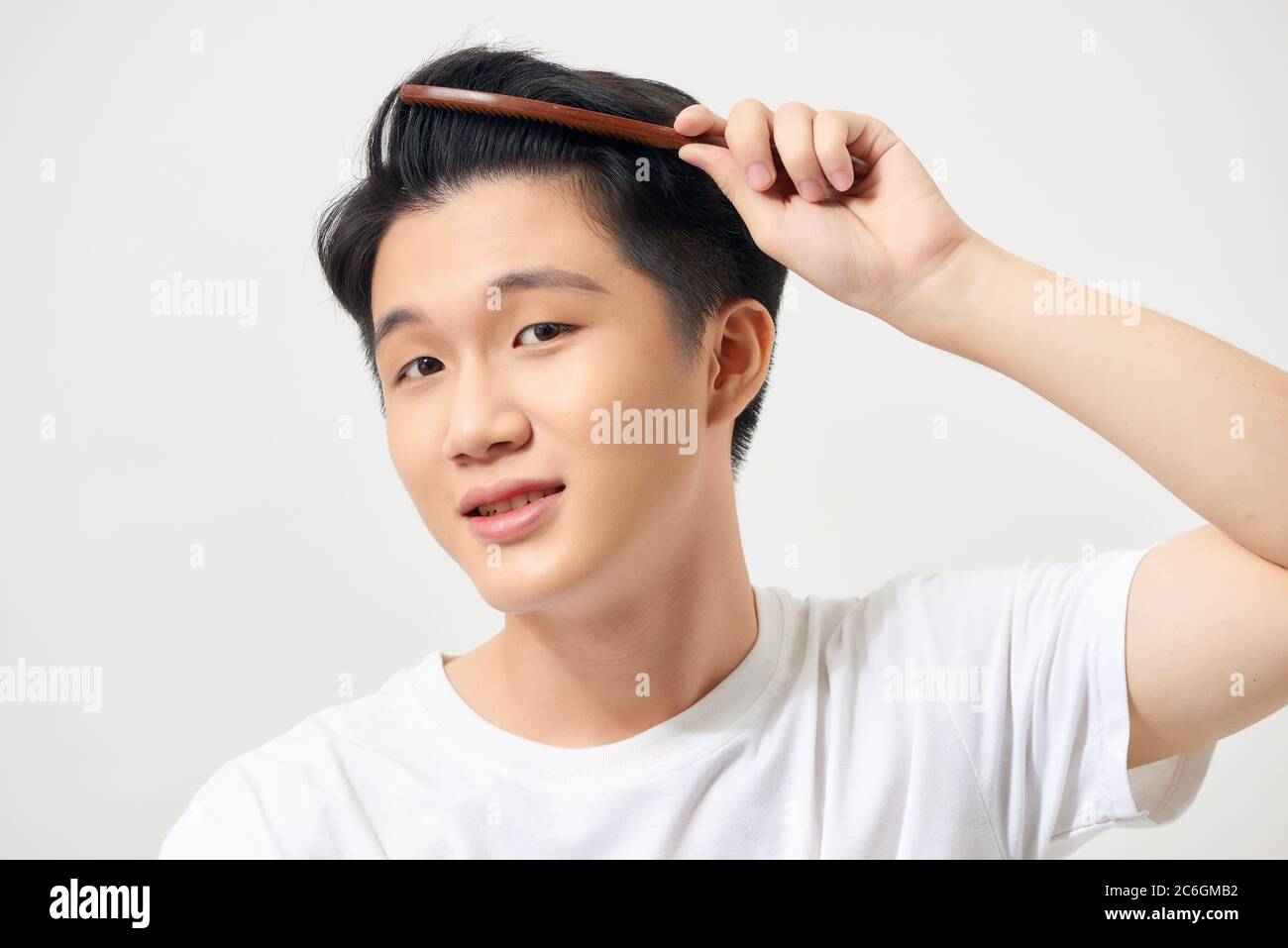 Handsome smiling young man doing coiffure moderne Banque D'Images