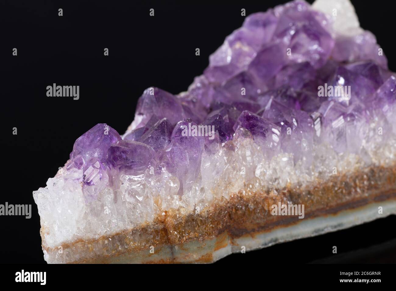 Géode de cluster de cristaux Quartz d'Améthyste violet sur fond noir Banque D'Images