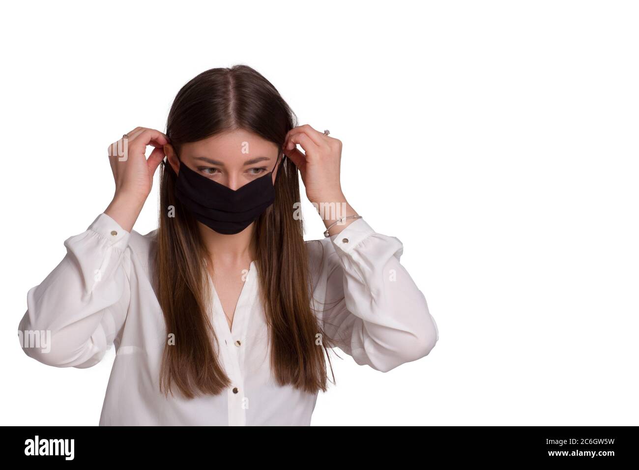 Une jeune femme porte un masque de protection noir. Isolé sur blanc. Le concept d'une épidémie virale. Éviter le covid-19 . Banque D'Images