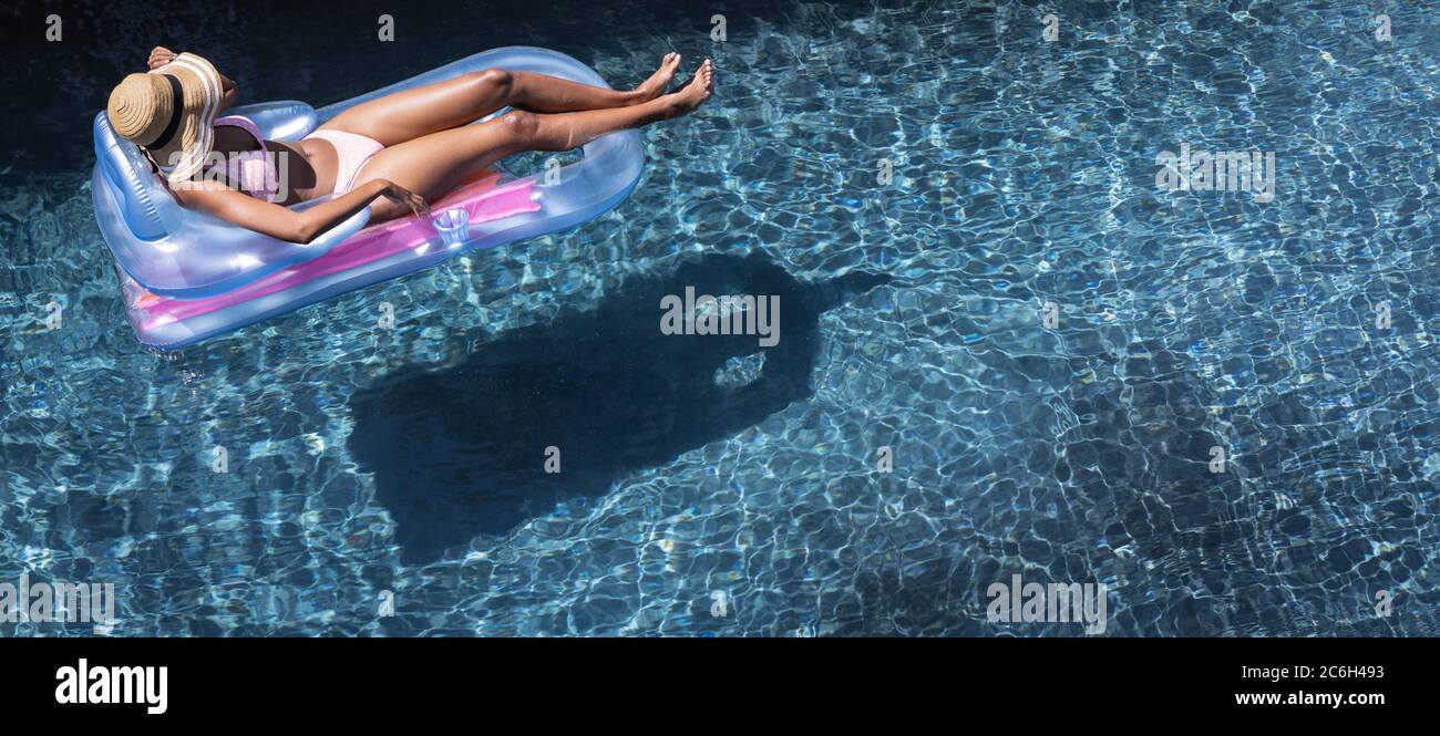 Femme flottant sur l'anneau gonflable dans la piscine Banque D'Images