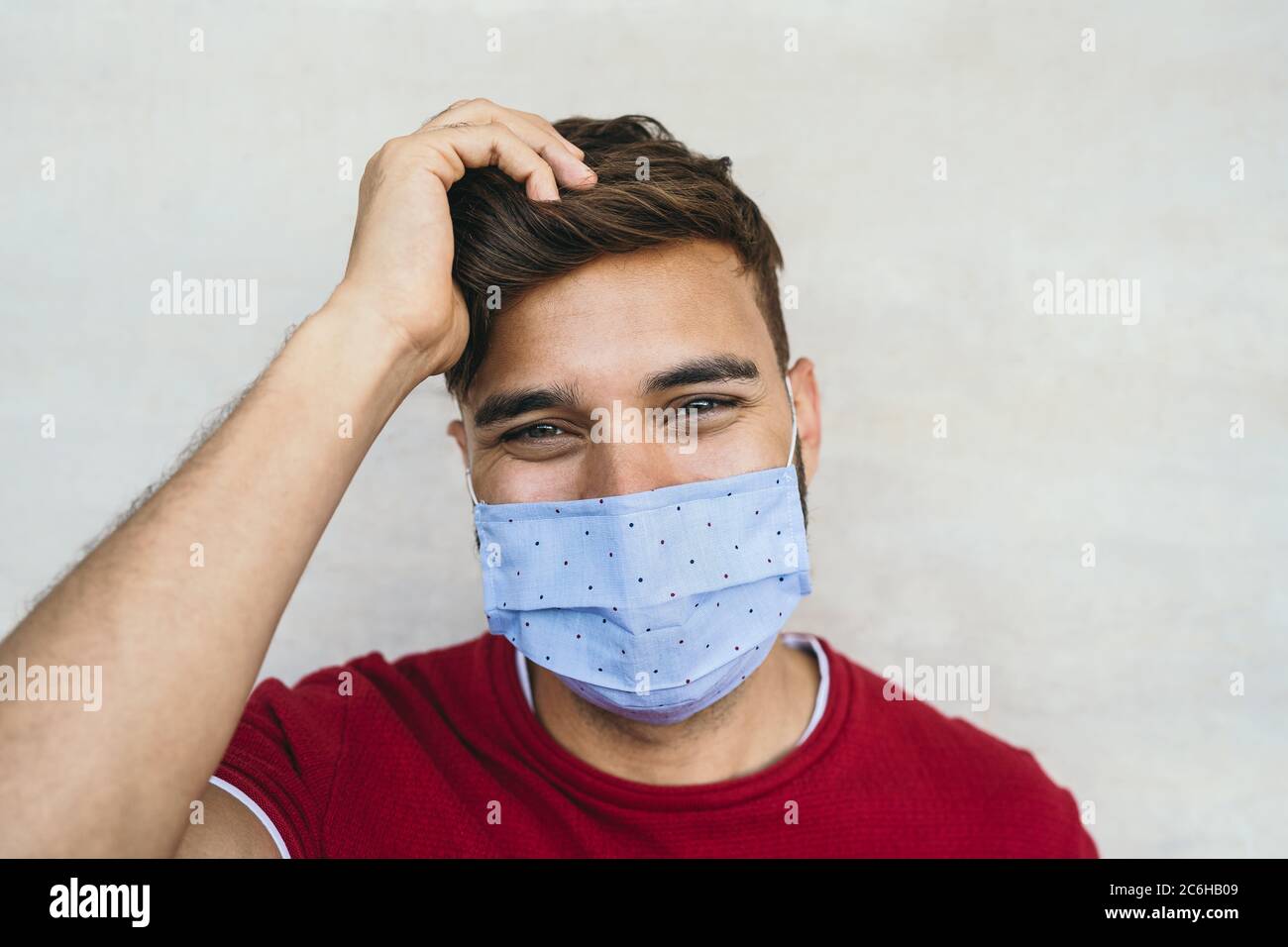 Jeune homme portant un masque facial portrait - garçon latin utilisant un masque facial protecteur pour prévenir la propagation du virus corona Banque D'Images