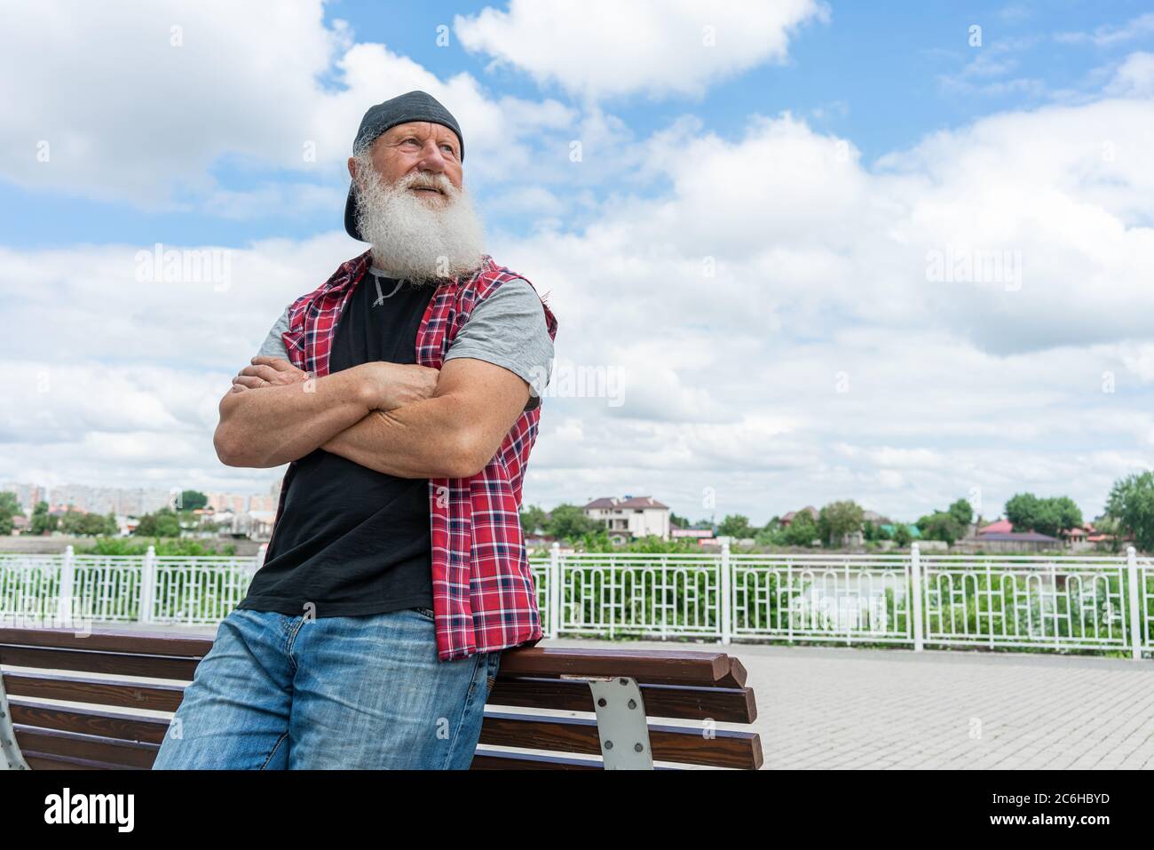 Vieux expérimenté avec barbe dans la rue posant et souriant, portrait Banque D'Images