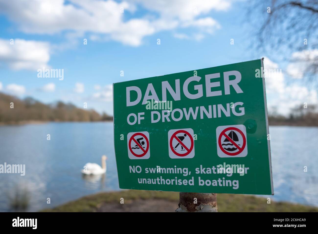 Vue détaillée d'un danger de noyade panneau voir placé près d'un grand et profond lac intérieur en Angleterre. Vue au coucher du soleil près des roseaux. Banque D'Images