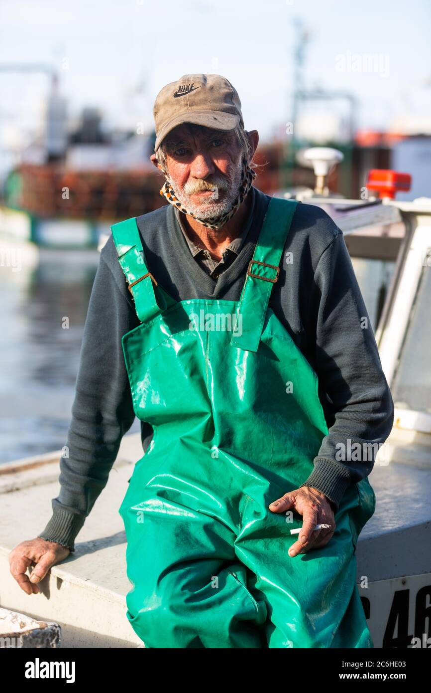 CAPE TOWN, AFRIQUE DU SUD – 4 JUILLET : vieux pêcheur non identifié sur bateau après avoir apporté les prises de la journée dans le port de Kalk Bay Banque D'Images