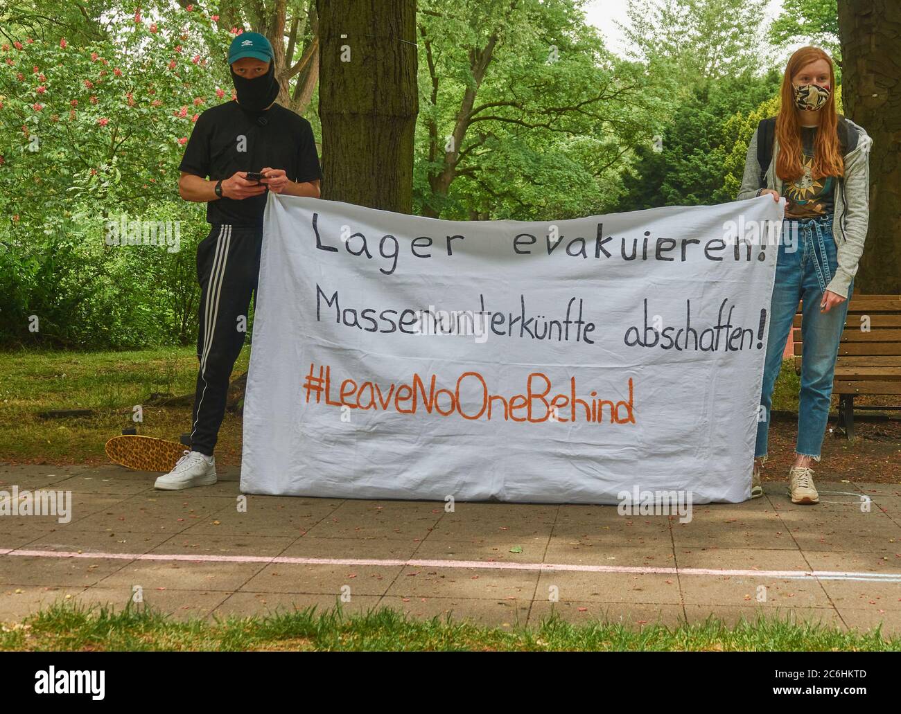 Hanovre, Allemagne, 23 mai 2020 : jeune femme à cheveux rouges et jeune homme avec masque facial et affiche sur l'abolition des camps d'accueil de réfugiés dans l'UE Banque D'Images