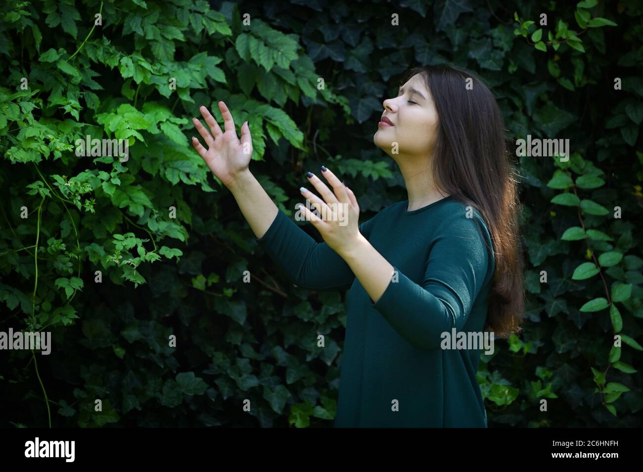 Beau portrait jeune femme priant dans la forêt Banque D'Images