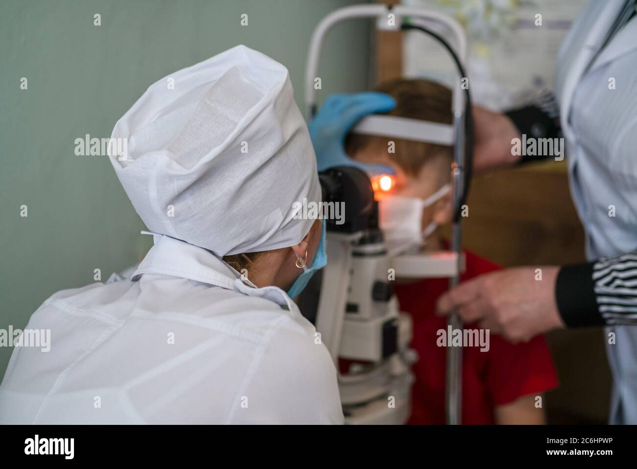 L'ophtalmologiste examine les yeux du garçon avec un équipement spécial. Banque D'Images