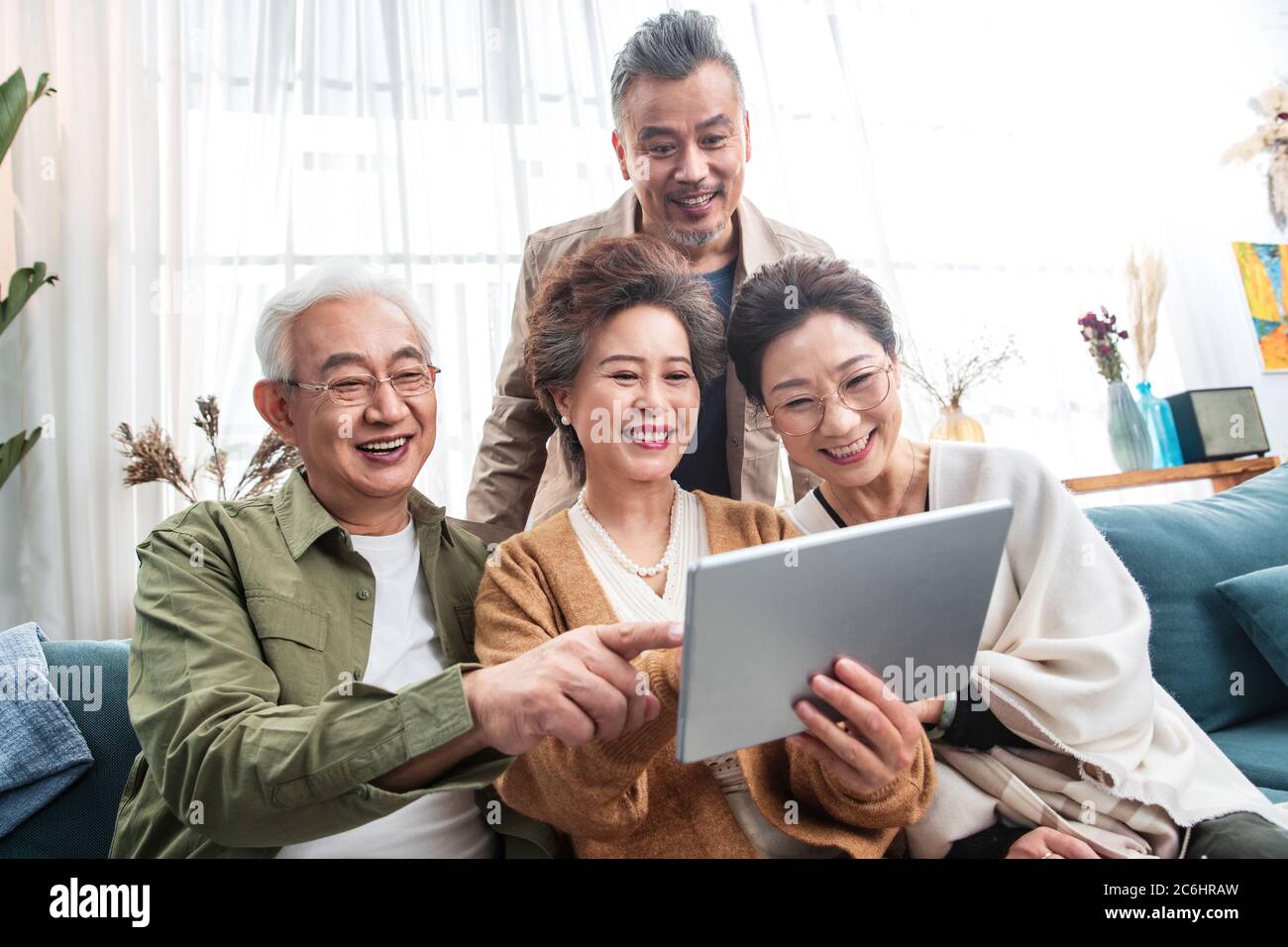 Les couples d'âge moyen sont heureux de regarder des tablettes Banque D'Images