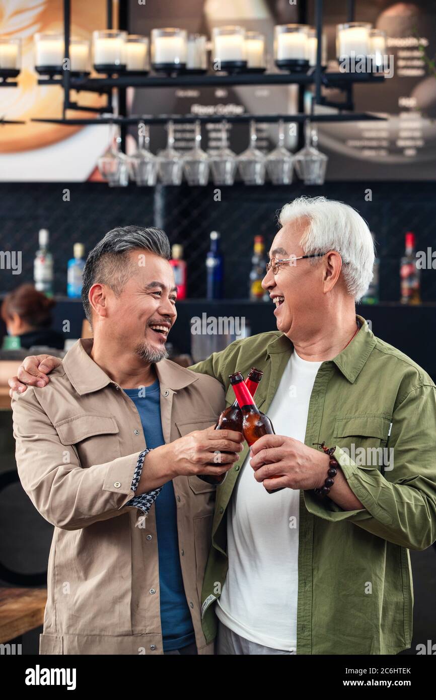 De vieux frères heureux de boire un toast pour célébrer l'occasion Banque D'Images