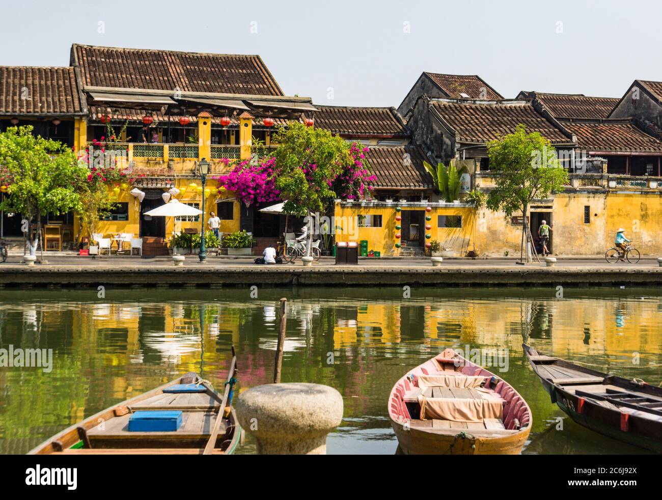 Scène de la vieille ville historique de Hoi an le long de la rivière avec des bateaux, lanternes, fleurs et les bâtiments jaune or Hoi an avec des toits de tuiles Banque D'Images