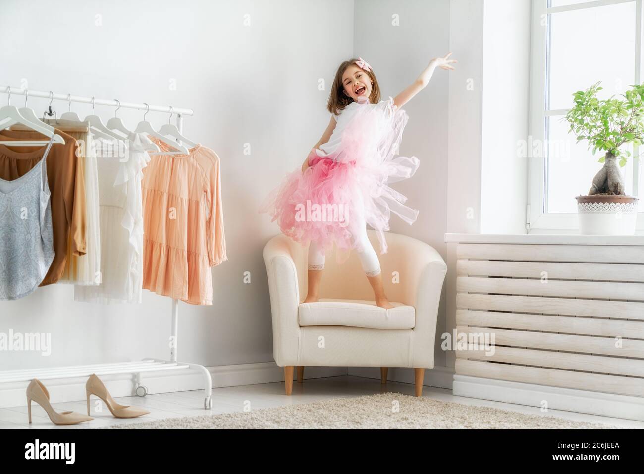 Bonne fille s'habiller à la maison. Drôle, un enfant adorable s'amuse dans la chambre. Banque D'Images