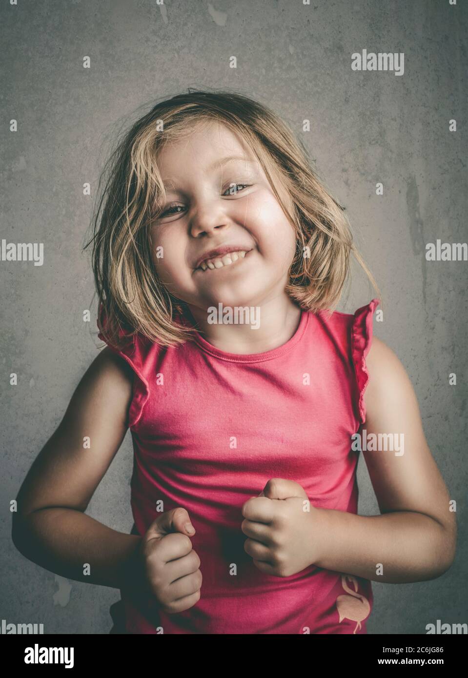 studio portrait d'une fille de 4 ans posant faisant un visage drôle. Banque D'Images