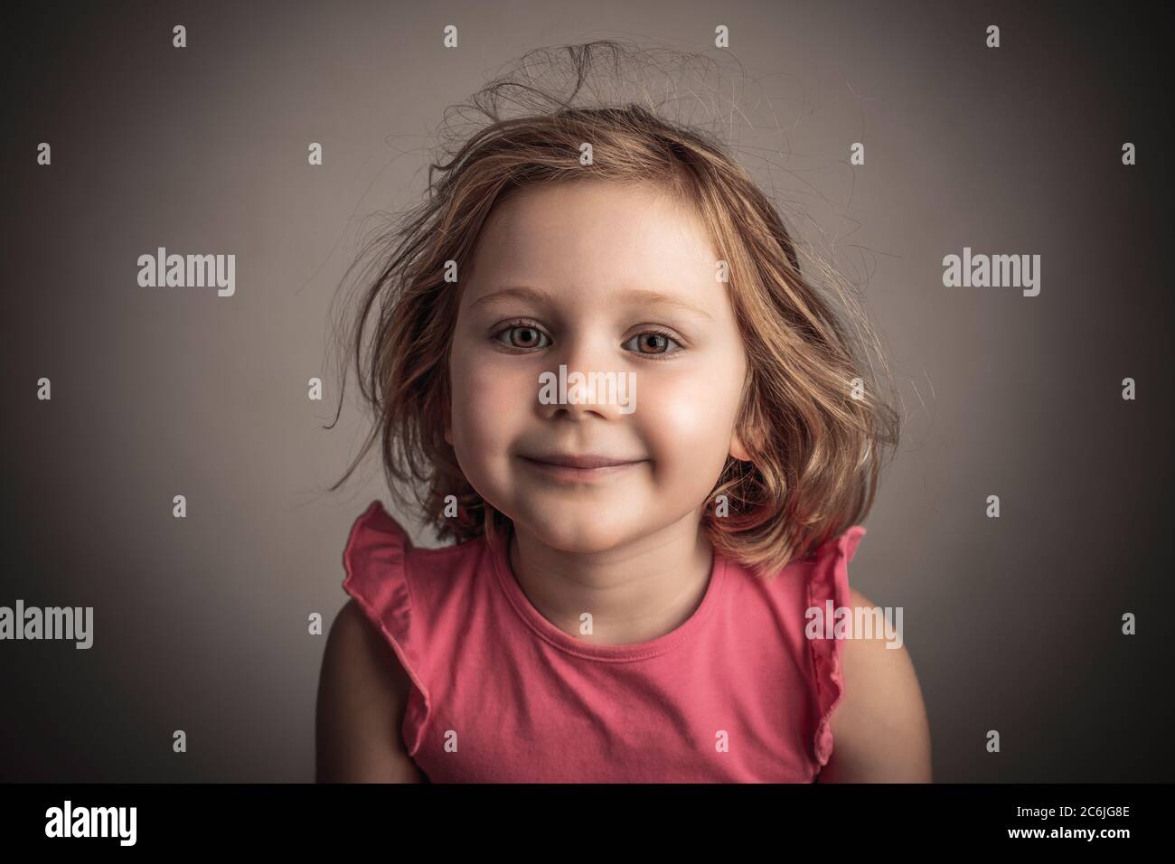 Portrait studio d'une fille de 4 ans regardant dans l'appareil photo. Banque D'Images