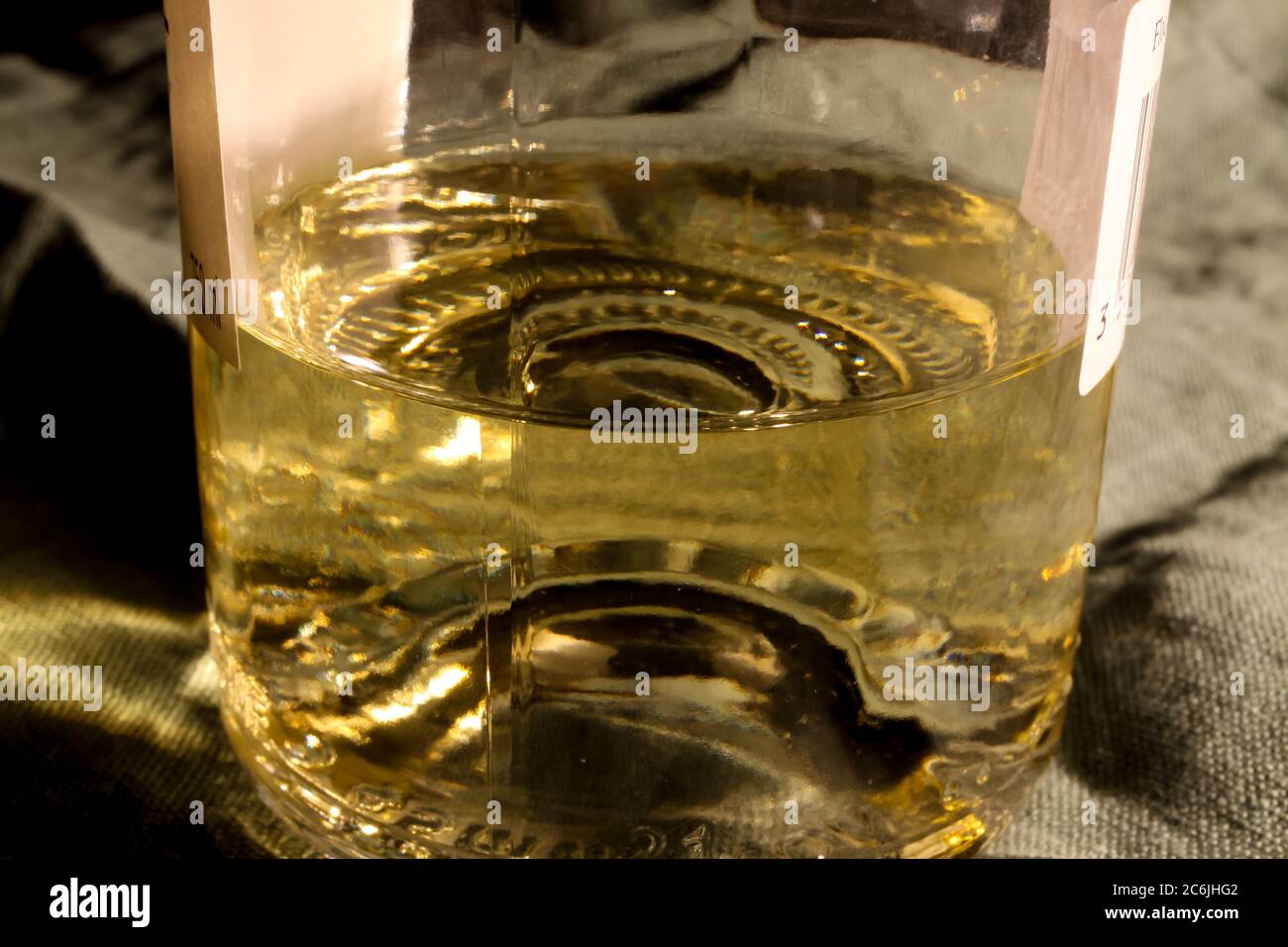 Vue sur la partie inférieure de la bouteille de vin blanc isolée avec le liquide restant sur la base Banque D'Images