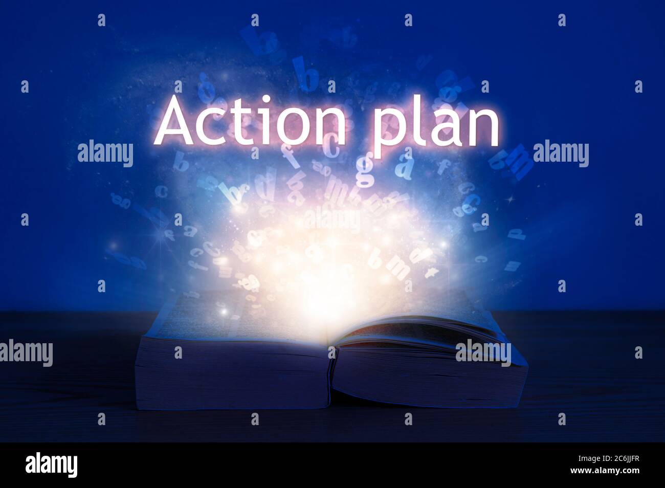 Livre ouvert avec inscription au plan d'action. Lumière venant d'un livre ouvert avec des mots plan d'action. Banque D'Images