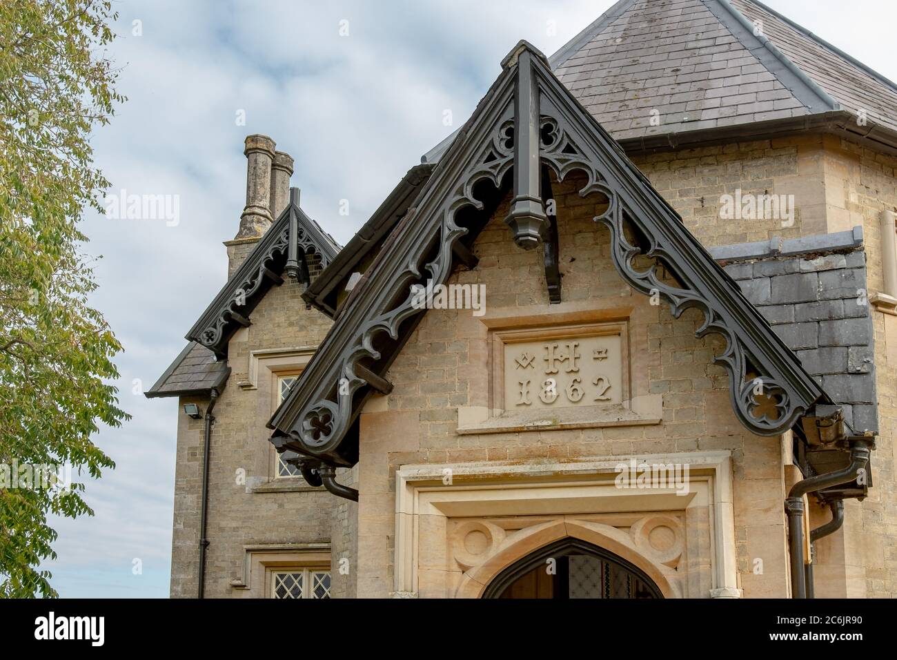 Vue détaillée d'une ancienne maison en pierre montrant le détail de la toiture avec une sculpture en brique à la date de la construction. Banque D'Images