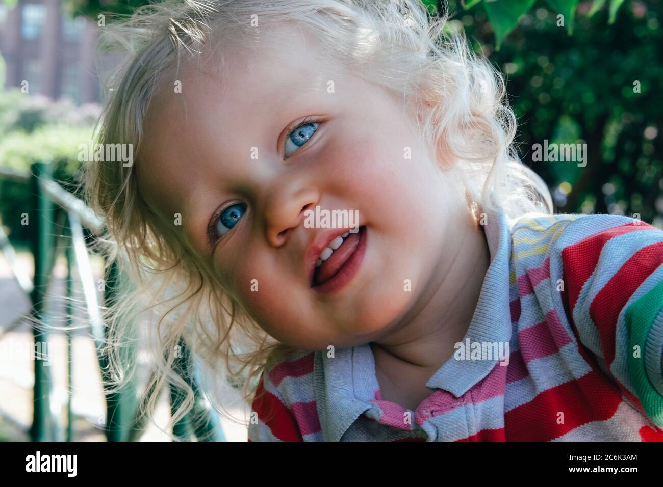 Portrait d'un joli petit garçon heureux avec des cheveux blonds et des yeux bleus, en train de faire un chapeau, de sourire et de jouer dans le parc. Retour au concept normal. Banque D'Images