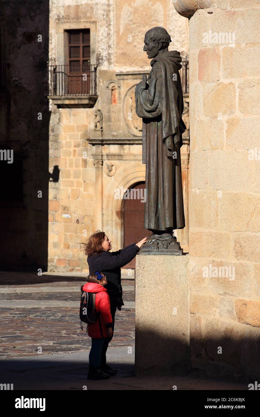 Une femme inconnue frotte les pieds de la statue de bronze de Saint Pierre d'Alcantra, un rituel pour les visiteurs. Site de l'UNESCO. 15 janvier 2017 : Caceres, Espagne. Banque D'Images