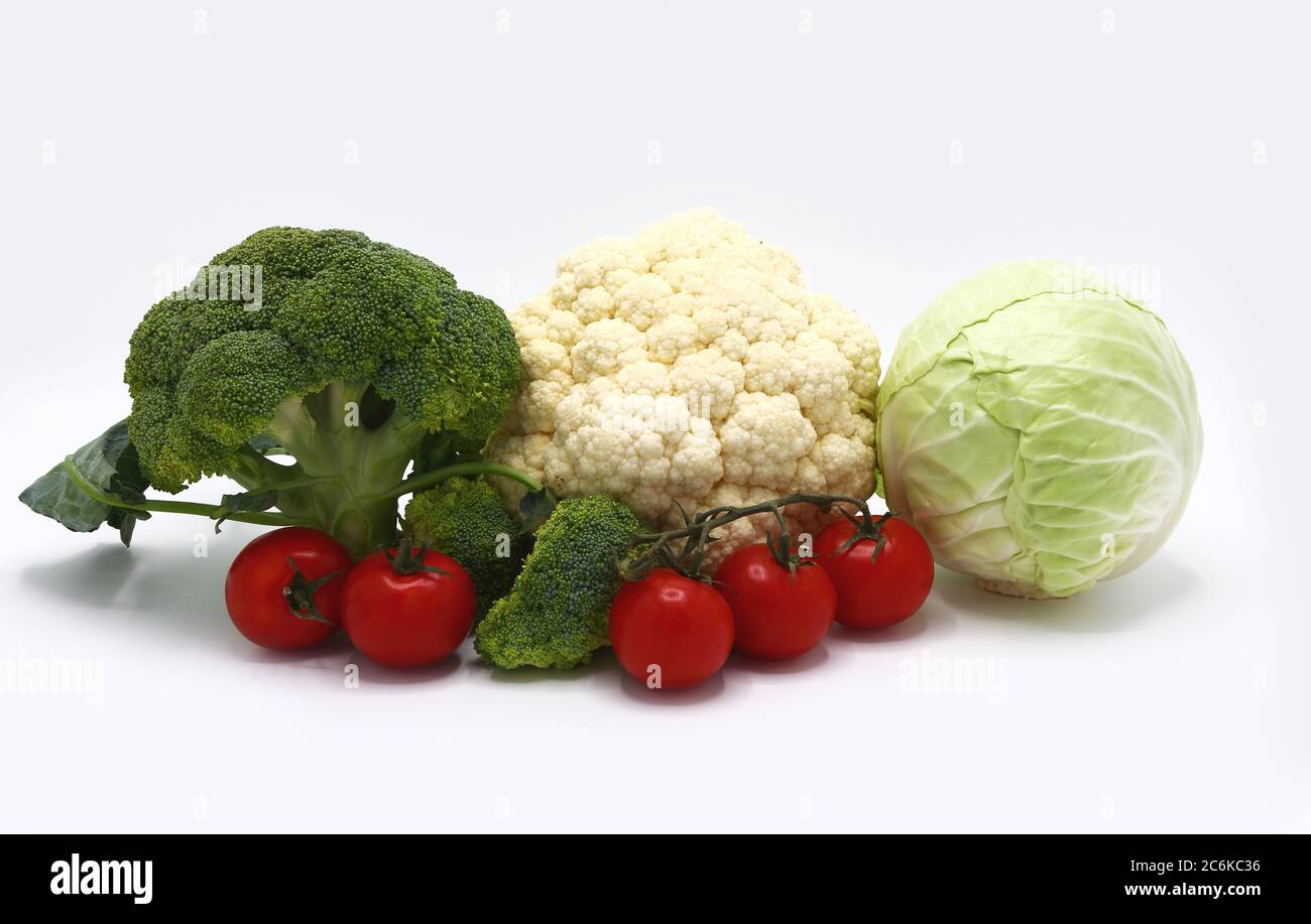 Tête de chou, inflorescences de brocoli et chou-fleur et tomates mûres rouges sur fond clair. Produit naturel. Teinte naturelle. Gros plan. Banque D'Images