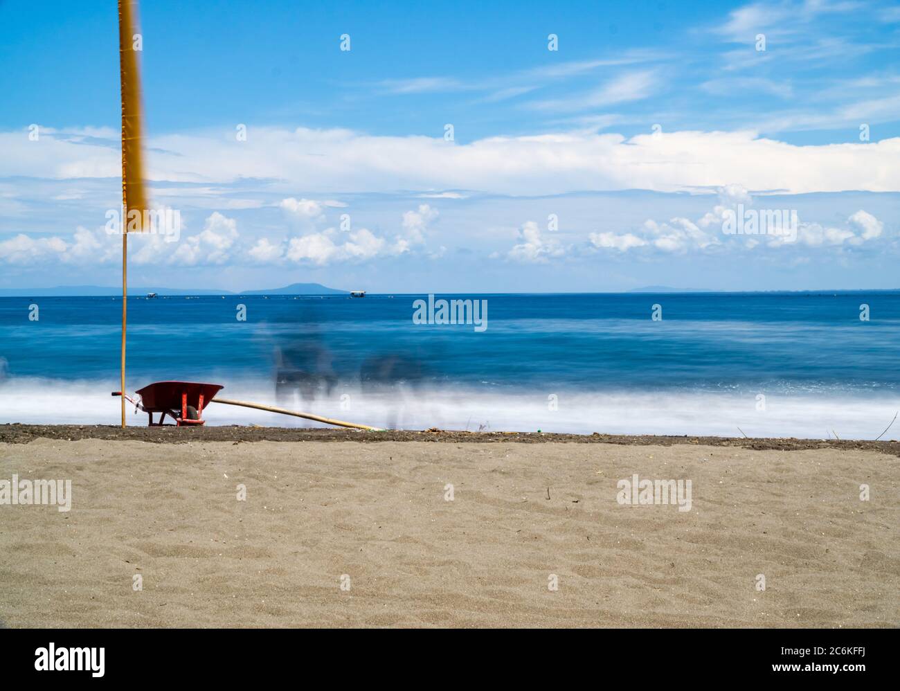 brouette rouge sur la plage. paysage marin en longue exposition Banque D'Images