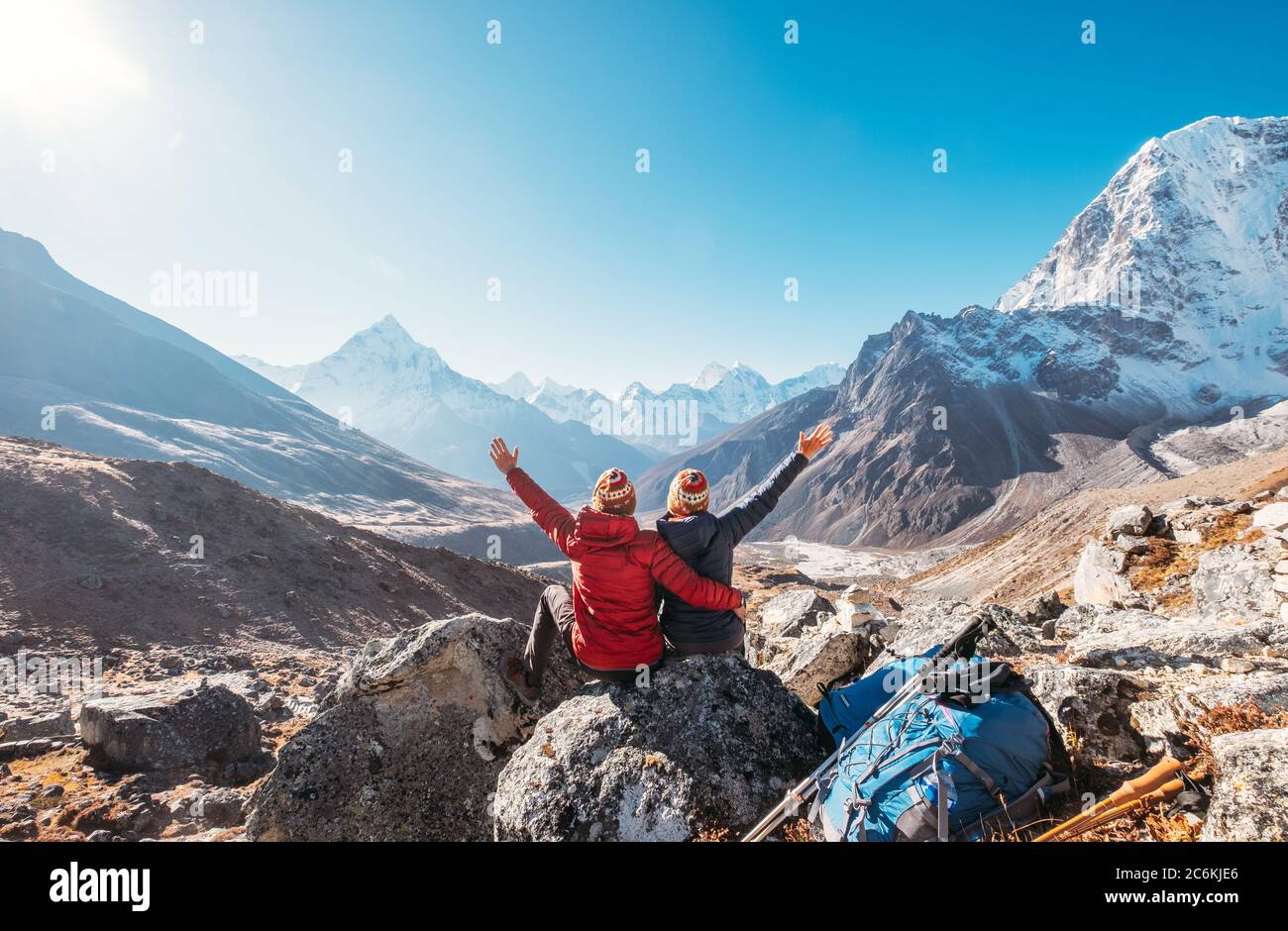 Couple en hausse d'armes se réjouissant de l'Everest base Camp randonnée  route près de Dughla 4620m. Backpackers a laissé des sacs à dos et des  bâtons de randonnée et appréciant la vallée