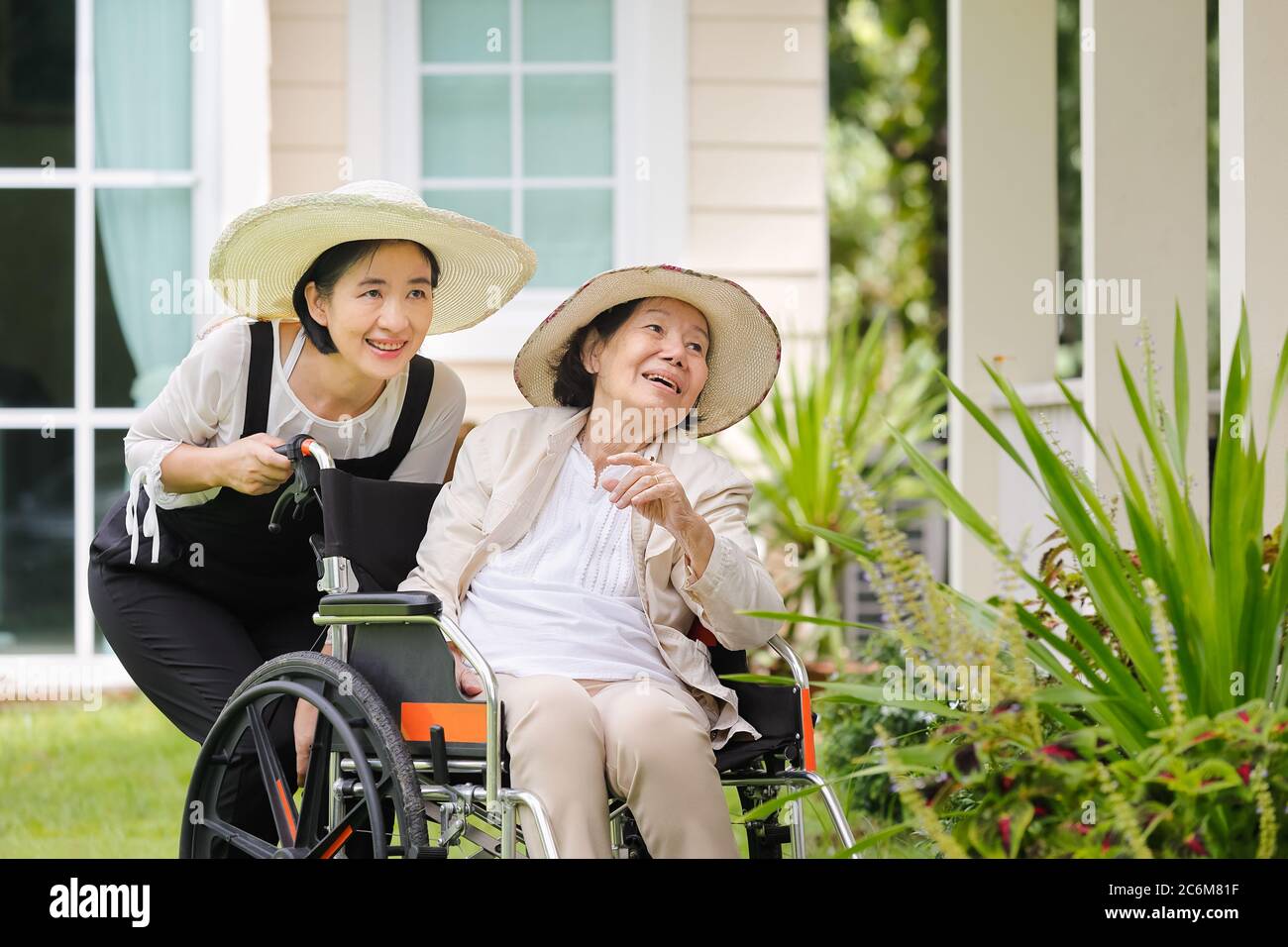 Femme âgée jardin dans l'arrière-cour avec fille Banque D'Images