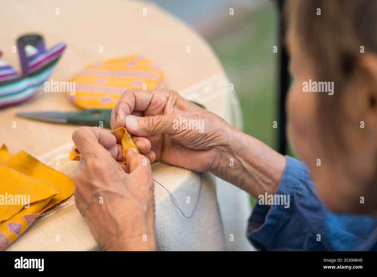 Une femme âgée qui a un soignant dans l’aiguille fait l’art de l’ergothérapie pour la maladie d’Alzheimer ou la démence Banque D'Images