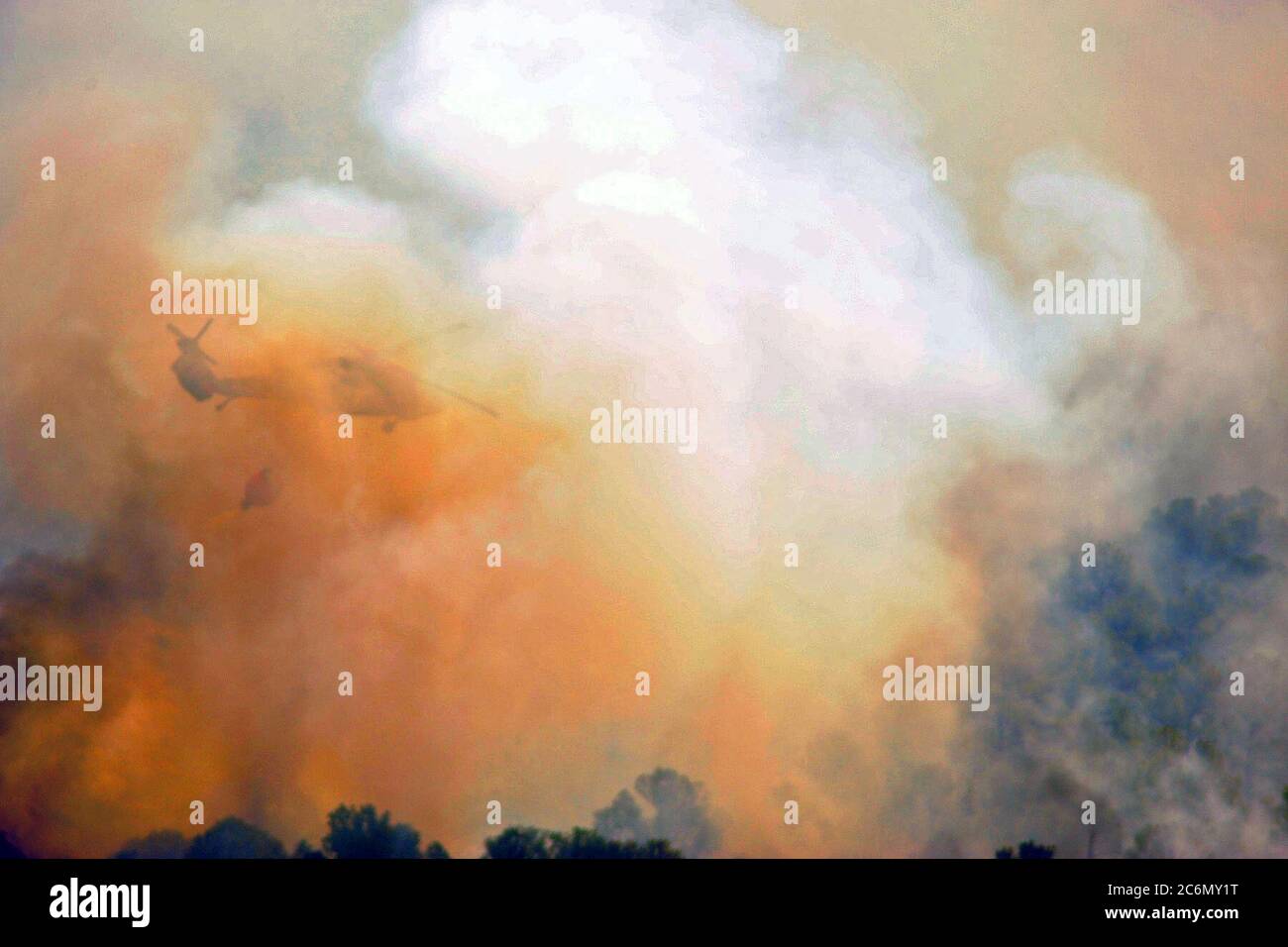 La Garde nationale du Texas UN UH-60 Black Hawk vole droit dans la fumée et déverse son eau sur le feu sauvage dans le centre du Texas Hill Country, près de Bastrop, Texas, le 6 septembre 2011. Les équipages de la Garde nationale du Texas a lancé hors de la Austin Army Aviation mondial à lutter contre les incendies qui menacent les maisons et les biens. Depuis 1975, le ministère de l'Agriculture et Ministère de l'Intérieur ont eu un accord interorganisations avec le ministère de la Défense (DOD) qui permet de fournir l'appui du Département de la lutte contre les incendies à l'organismes de gestion des feux en cas de besoin. Depuis 1975, le département américain de l'Agroalimentaire Banque D'Images