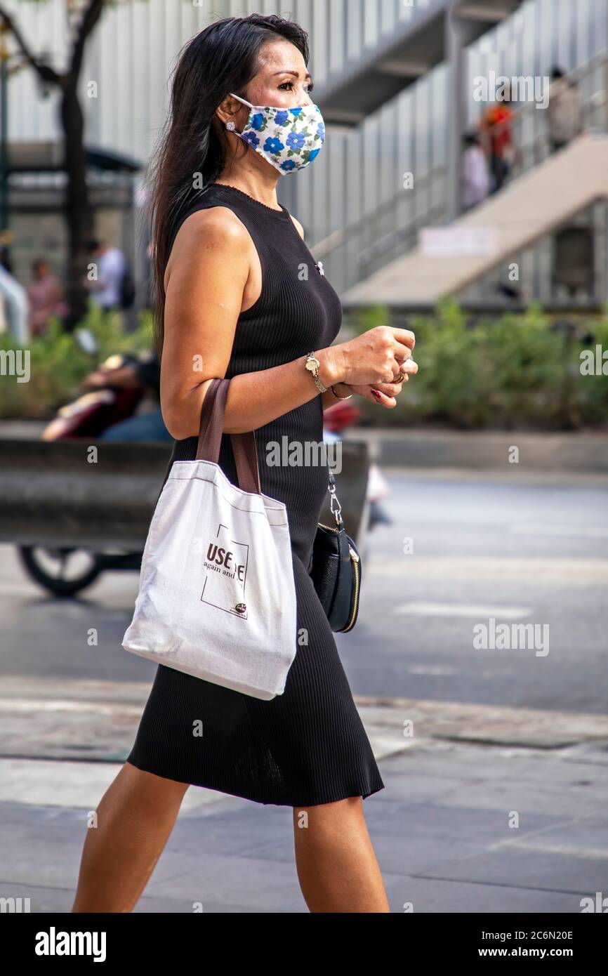 Dame avec masque facial et sac de shopping recyclé marchant dans la rue pendant la pandémie Covid 19, Sukhumvit, Bangkok, Thaïlande Banque D'Images