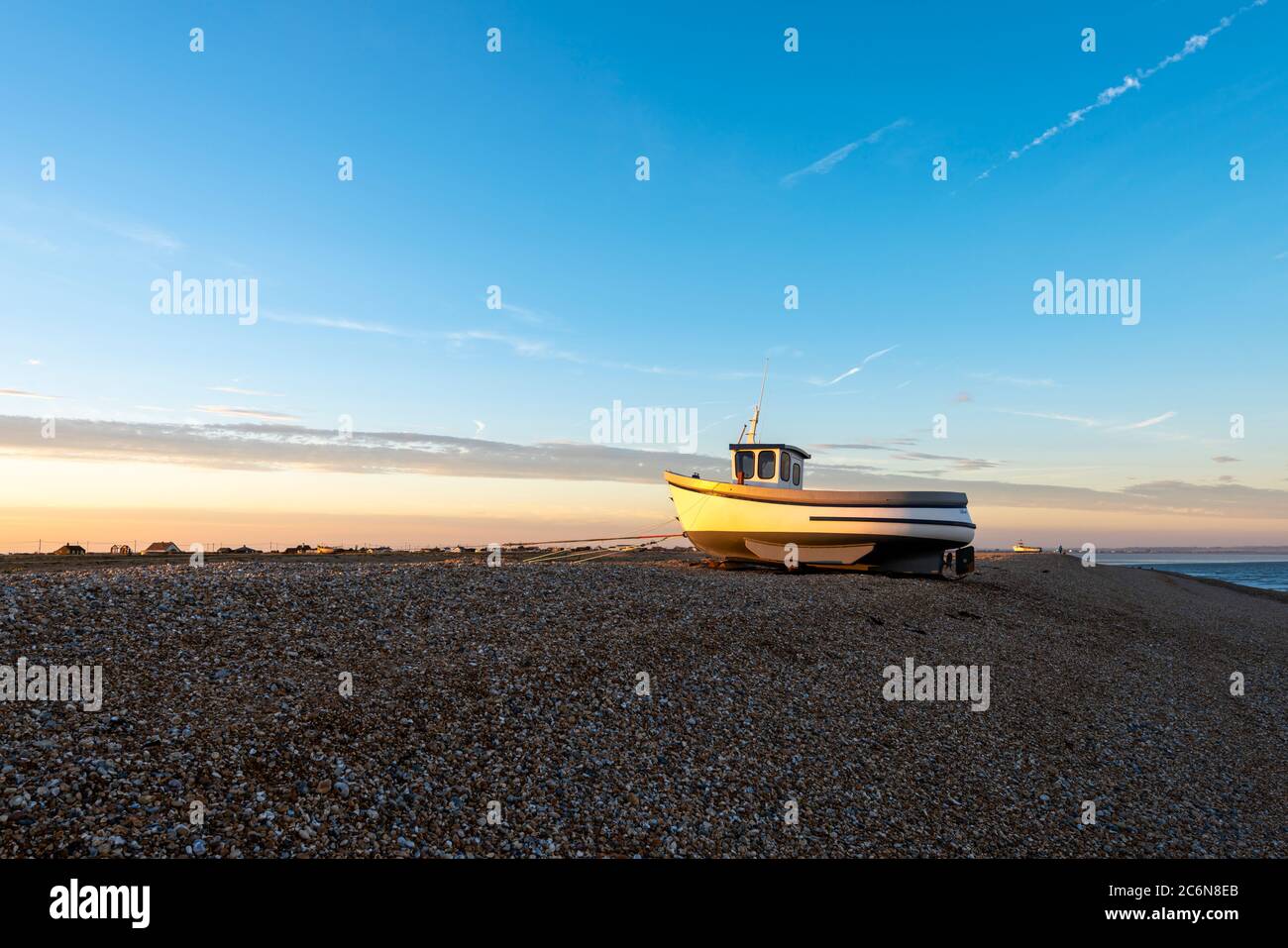 Un seul bateau de pêche sur les étendues de galets à Dungeness, Kent. Banque D'Images