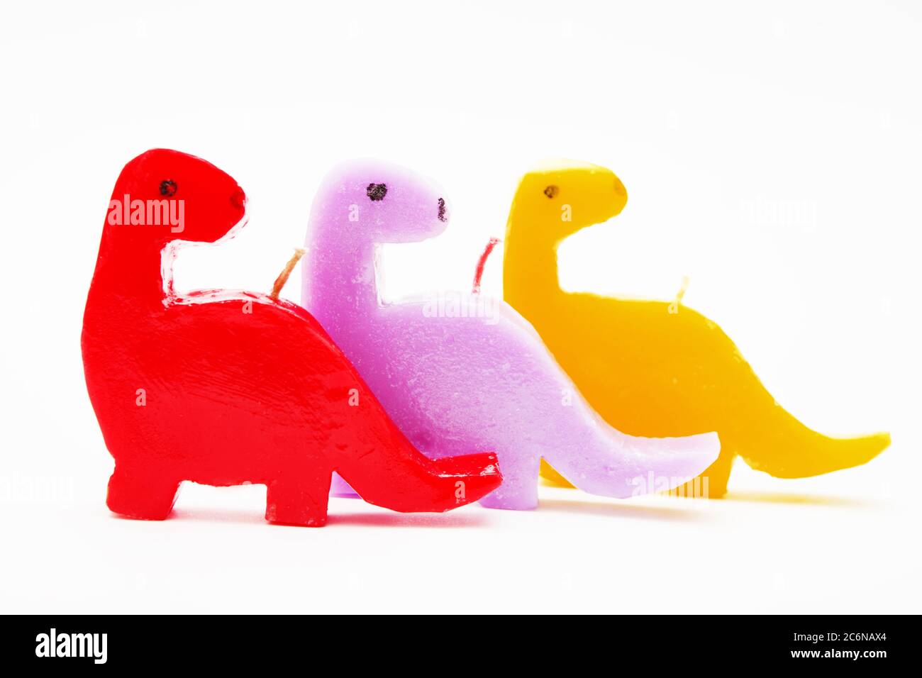 Bougies cadeau souvenir drôles en forme de dragons multicolores. Une bougie allumée en blanc. Bougie allumée. Banque D'Images Bougies cadeau souvenir drôles en forme de dragons multicolores. Une bougie allumée en blanc. Bougie allumée. Banque D'Images