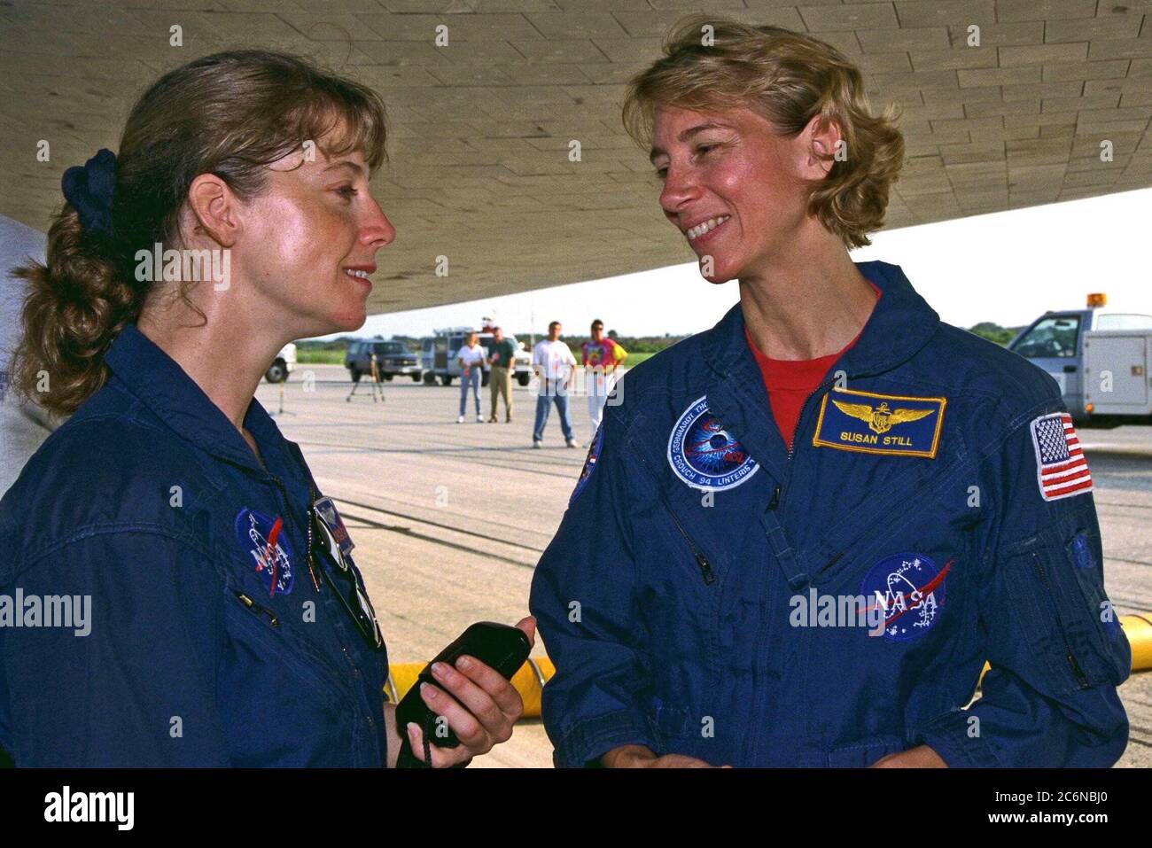 CENTRE SPATIAL KENNEDY, FLA. -- Pamela A. Melroy, membre de l’équipe de soutien aux astronautes (à gauche), salue la pilote STS-94 Susan L. toujours sous l’orbiteur de la navette spatiale Columbia après un atterrissage en fin de mission sur la piste 33 de l’installation d’atterrissage de la navette de KSC le 17 juillet pour terminer la mission du Laboratoire scientifique de microgravité 1 (MSL-1). Banque D'Images