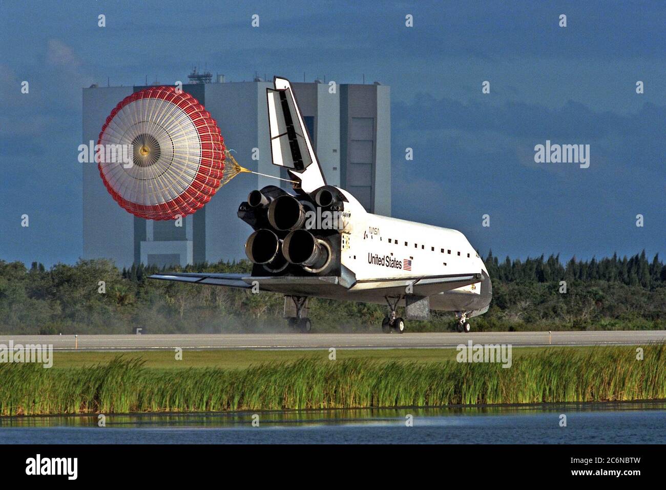 KENNEDY SPACE CENTER, Fla -- la rampe de déchargement orbiteur se déploie après que l'orbiteur de la navette spatiale Atlantis atterrit sur la piste 15 de la KSC Shuttle Landing Facility (SLF) à la fin de la mission STS-86 de près de 11 jours. Le bâtiment d'assemblage de véhicules (VAB) est visible en arrière-plan. Le touchdown de l'engrenage principal était à 5 h 55 h 09 HAE, le 6 octobre 1997, avec un temps non officiel de la mission écoulé de 10 jours, 19 heures, 20 minutes et 50 secondes. Les deux premières possibilités d'atterrissage du KSC dimanche ont été ondulées en raison de problèmes météorologiques. La 87e mission de la navette spatiale a été le 40ème atterrissage de la navette à KSC Banque D'Images