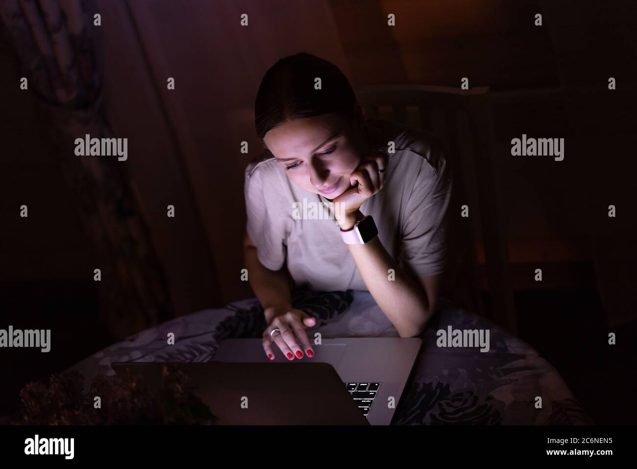 Femme indépendante travaillant sur ordinateur portable tard dans la nuit à la maison, partageant les médias sociaux. Travail à distance Banque D'Images