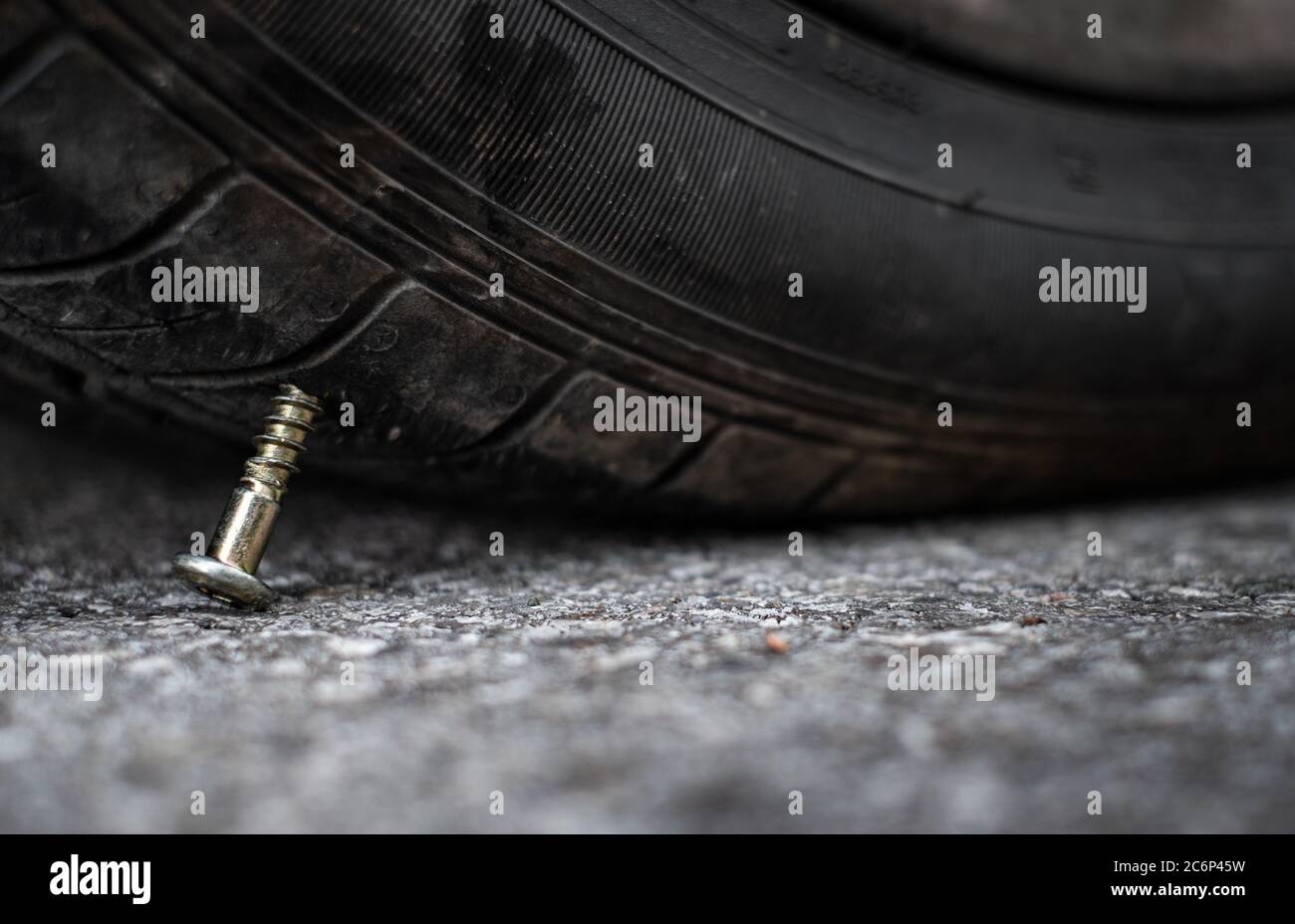 Gros plan de la tête de bouton aiguille de la vis métallique clou coincé  pour percer dans le pneu de roue sur la route Photo Stock - Alamy