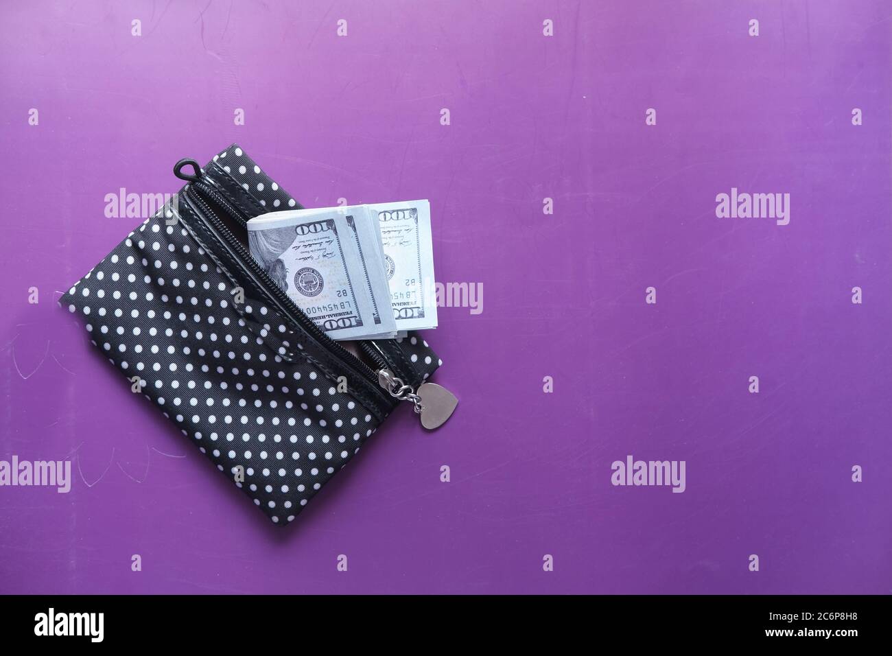 Gros plan sur un dollar américain dans un portefeuille sur fond violet. Banque D'Images