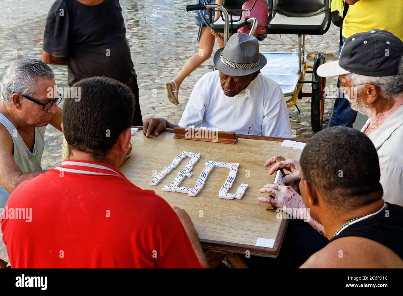 TRINIDAD,CUBA-NOV 23,2013: Vieil homme dans la rue de Trinidad jouant au domino, qui est un jeu typique pour les Cubains qui se rassemblent souvent pour jouer en plein air Banque D'Images