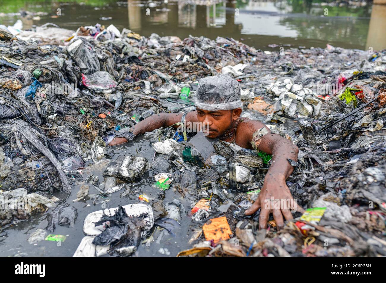 Savar, Bangladesh. 11 juillet 2020. Un volontaire est à la source des ordures tout en travaillant à nettoyer un canal obstrué par des déchets urbains près de Dhaka. Crédit: Zabed Hasnain Chowdhury/ZUMA Wire/Alay Live News Banque D'Images