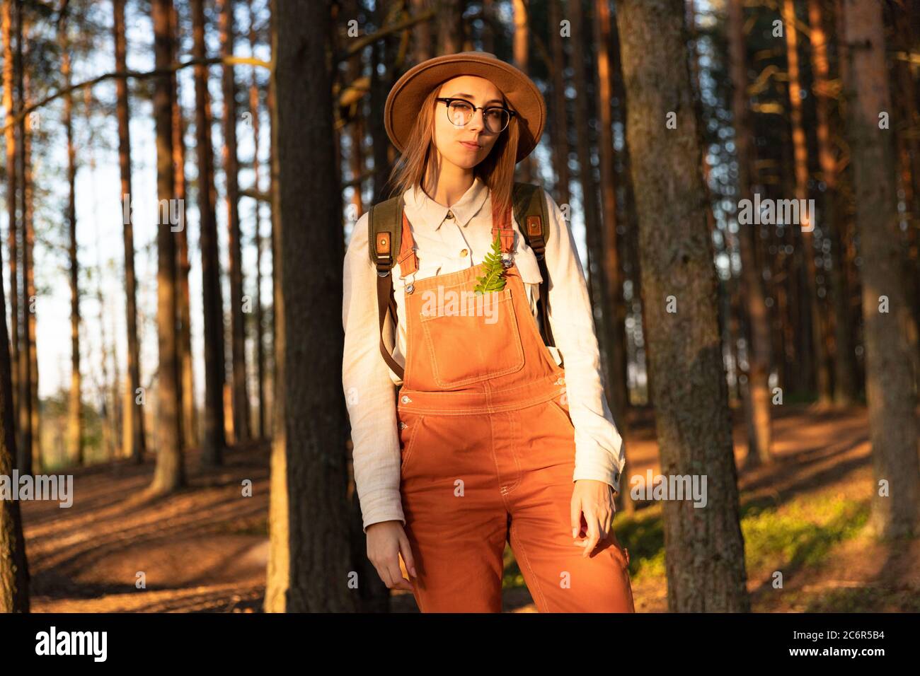 Portrait de femme botaniste avec sac à dos sur un sentier écologique de randonnée en été. Naturaliste explorant la faune et l'écotourisme aventure marchant dans un wil Banque D'Images