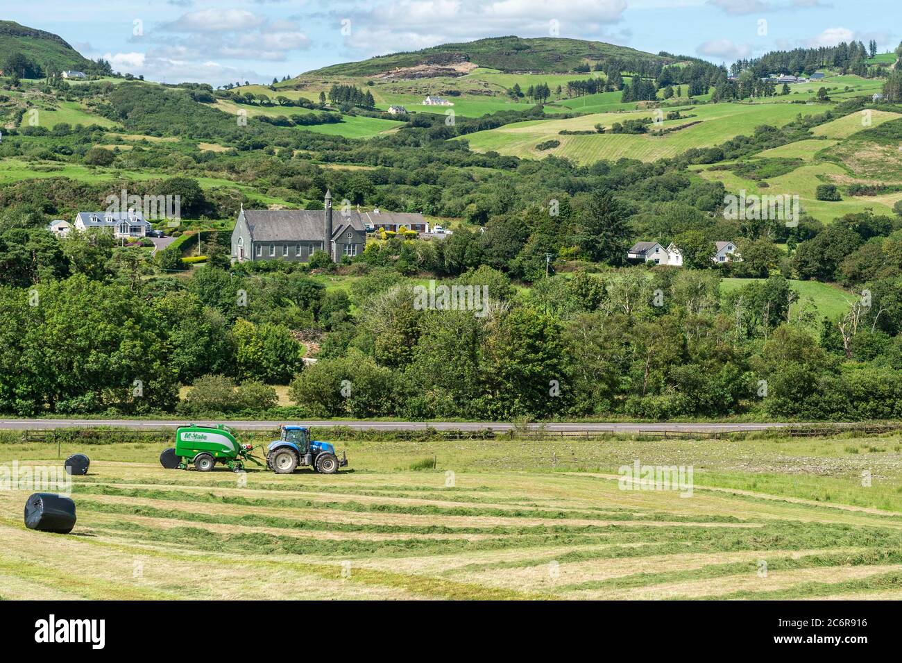 Bantry, West Cork, Irlande. 11 juillet 2020. Par temps chaud et ensoleillé, Whooley Contractors fabrique de l'ensilage sur la ferme de Pat Cadogan à Aughaville, près de Bantry, à l'aide d'un tracteur New Holland et d'une presse McHale Fusion 3 plus. Crédit : AG News/Alay Live News Banque D'Images