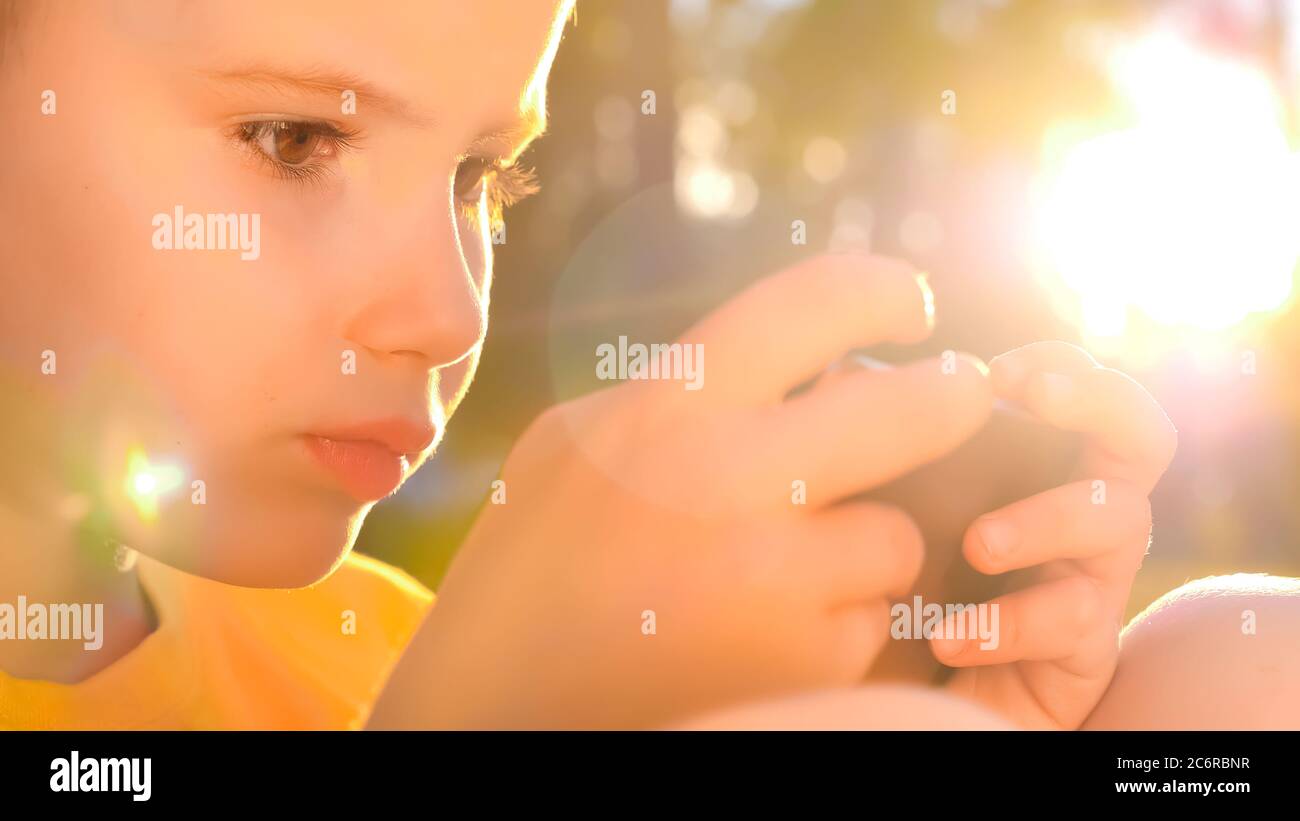 Jeune joueur jouant sur mobile. Enfant avec smartphone. Enfants et technologie. Jeu en ligne, arrière-plan de l'application mobile. Génération de technologie Banque D'Images