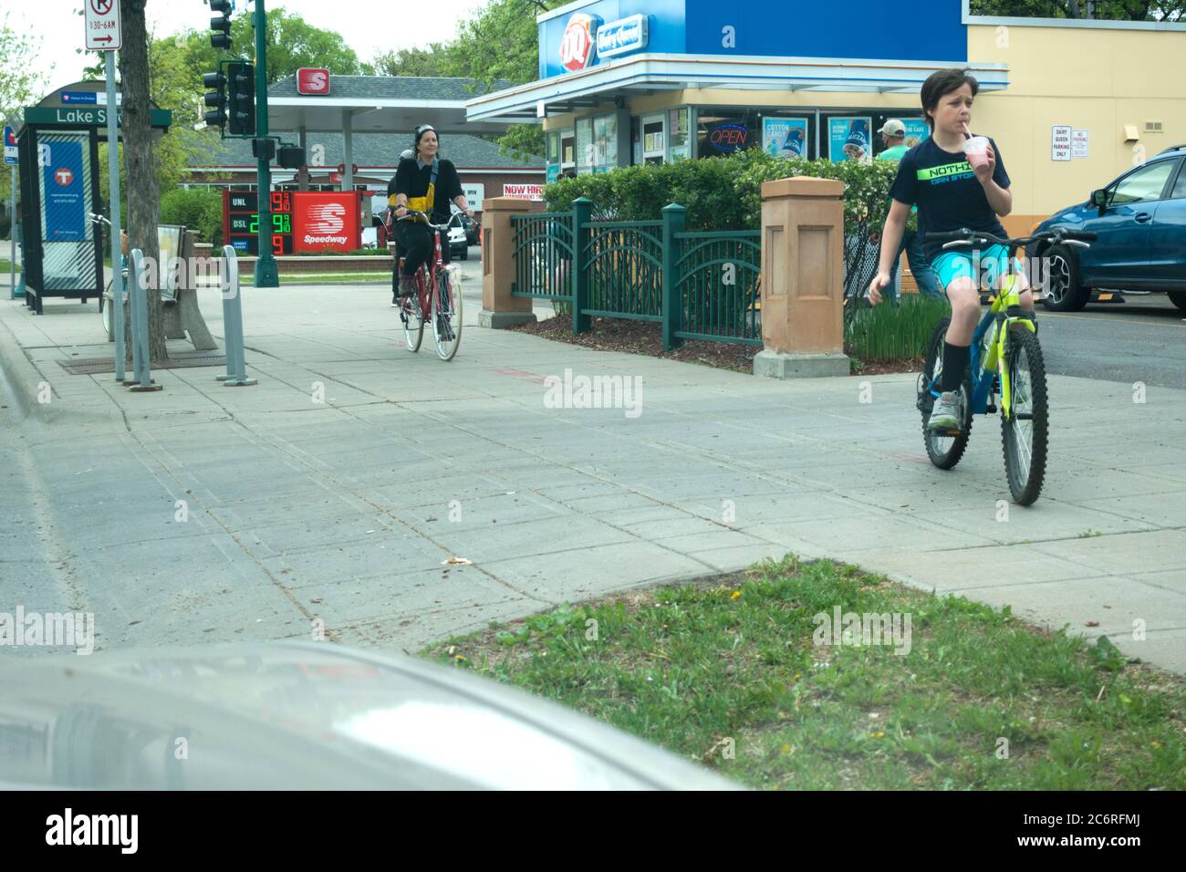 Garçon quitte Dairy Queen en vélo pendant qu'il soufiltre sa boisson à travers une paille. Minneapolis Minnesota MN États-Unis Banque D'Images