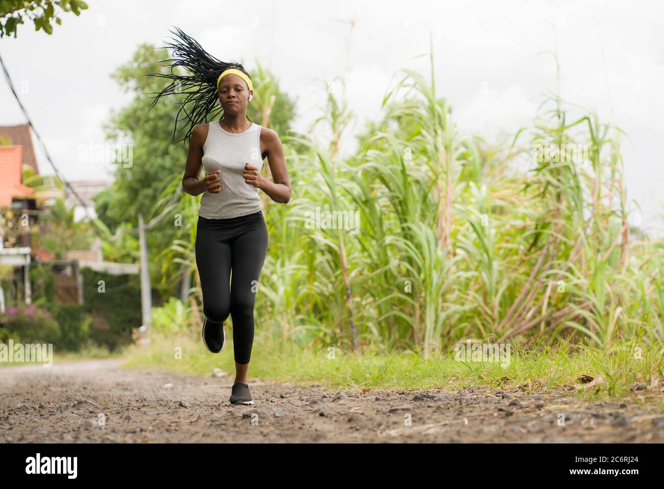 Jeune fille de coureur noir appréciant l'entraînement de jogging extérieur - jeune attrayante et en forme femme afro-américaine courir à la campagne sur la route dans le prac sport Banque D'Images