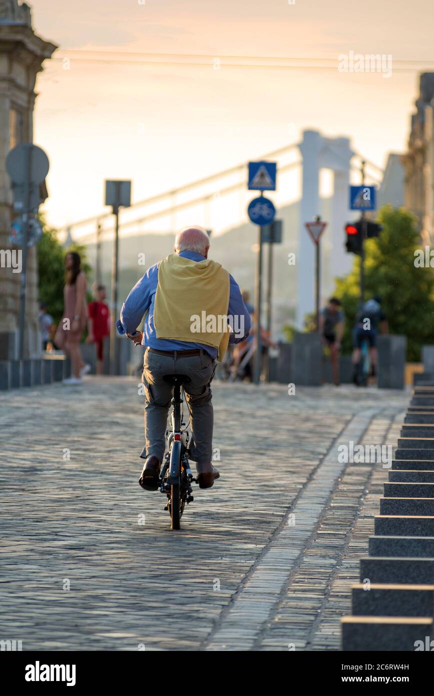 Homme aîné à vélo dans la ville, vue arrière Banque D'Images
