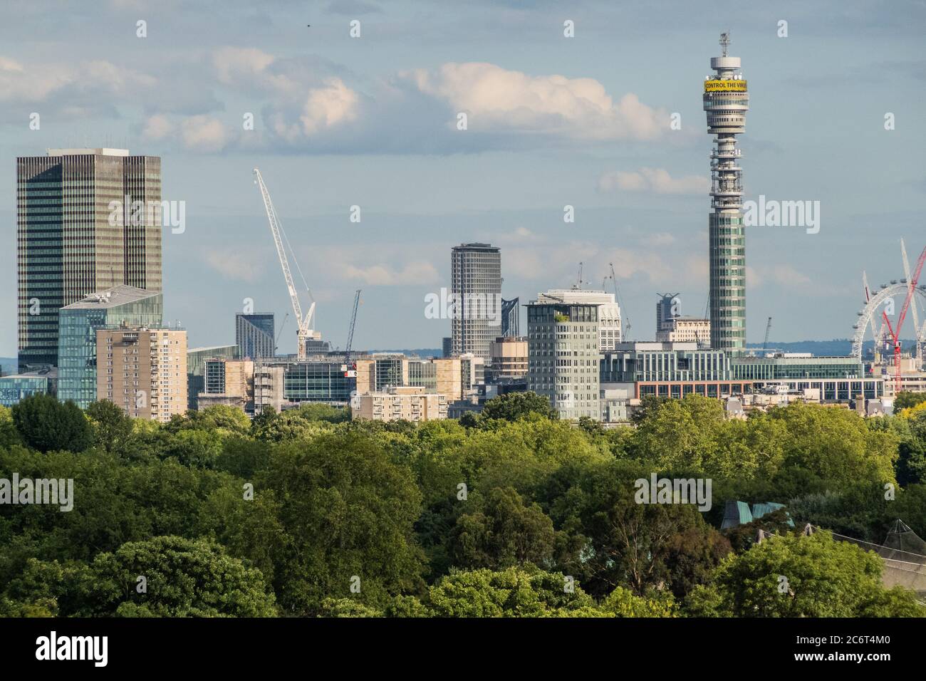 Londres, Royaume-Uni. 11 juillet 2020. La tour BT continue d'afficher le message du gouvernement de 'alerte de jour, contrôler le virus' - les gens profitent d'une soirée ensoleillée sur Primrose Hill surplombant la ville. Le « verrouillage » continue d'être atténué pour l'épidémie de coronavirus (Covid 19) à Londres. Crédit : Guy Bell/Alay Live News Banque D'Images