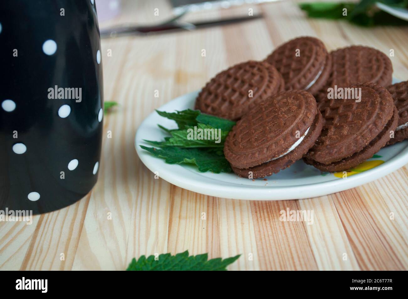 Portion de biscuits aux pépites de chocolat, une tasse de thé sur fond de bois. Empiler les biscuits aux pépites de chocolat et le thé. Biscuits au chocolat sur l'assiette et une tasse noire Banque D'Images